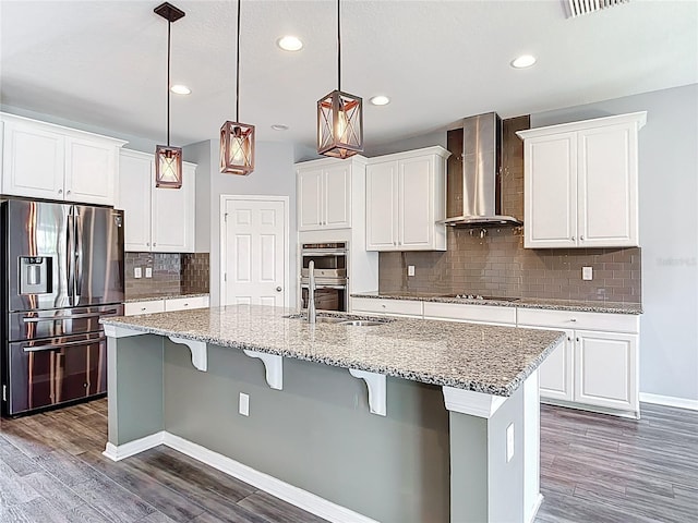 7628 Surf Reed Way, Wesley Chapel, FL 33545 - kitchen with appliances with stainless steel finishes, wall chimney range hood, dark wood-type flooring, white cabinetry, and recessed lighting