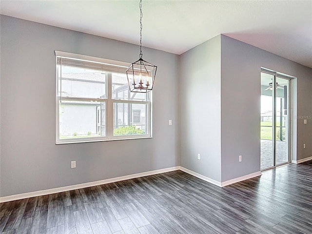 7628 Surf Reed Way, Wesley Chapel, FL 33545 - spare room with healthy amount of natural light, a chandelier, dark wood-style flooring, and baseboards
