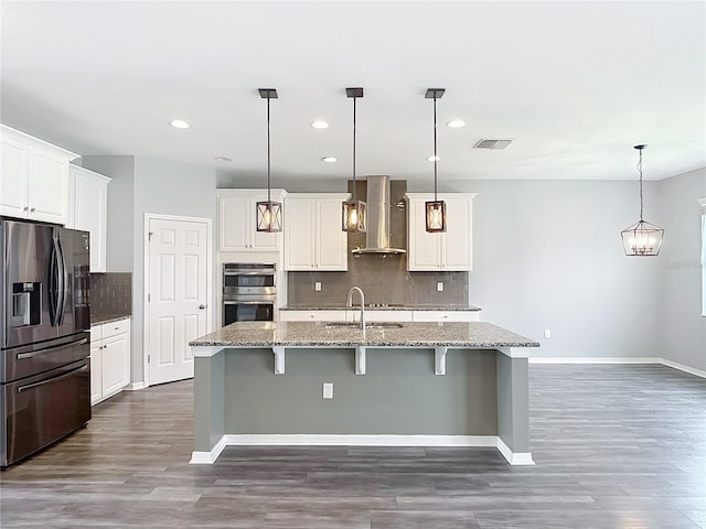 7628 Surf Reed Way, Wesley Chapel, FL 33545 - kitchen featuring stainless steel appliances, wall chimney range hood, a sink, dark wood-type flooring, and recessed lighting