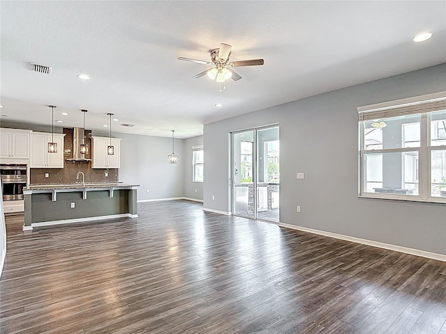 7628 Surf Reed Way, Wesley Chapel, FL 33545 - unfurnished living room with ceiling fan, dark wood-style flooring, a sink, recessed lighting, and baseboards