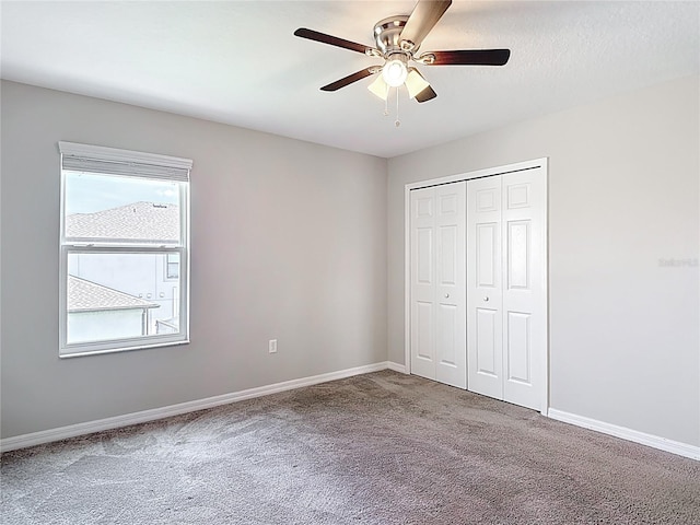 7628 Surf Reed Way, Wesley Chapel, FL 33545 - unfurnished bedroom with carpet flooring, a closet, baseboards, and a ceiling fan