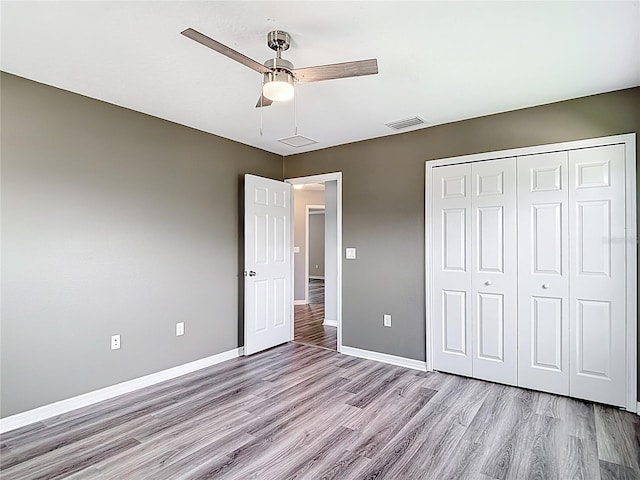 7628 Surf Reed Way, Wesley Chapel, FL 33545 - unfurnished bedroom featuring light wood-style flooring, baseboards, a closet, and a ceiling fan