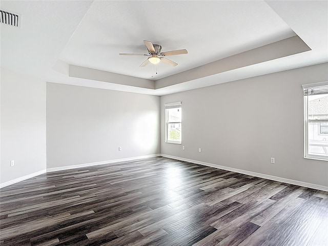 7628 Surf Reed Way, Wesley Chapel, FL 33545 - spare room with a tray ceiling, a ceiling fan, dark wood-type flooring, and baseboards