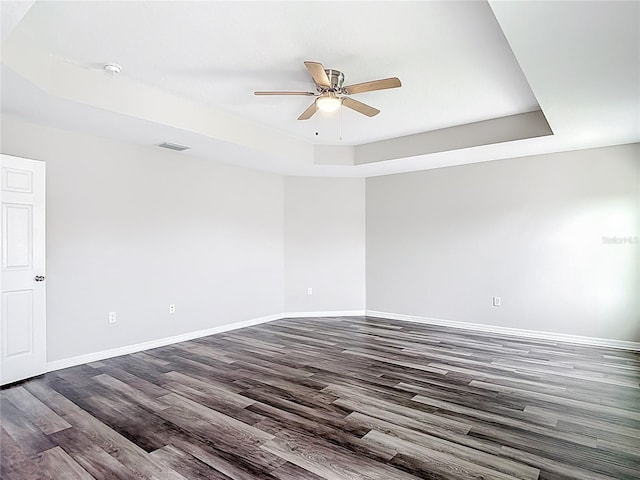 7628 Surf Reed Way, Wesley Chapel, FL 33545 - spare room featuring a raised ceiling, dark wood-style floors, ceiling fan, baseboards, and a smoke detector