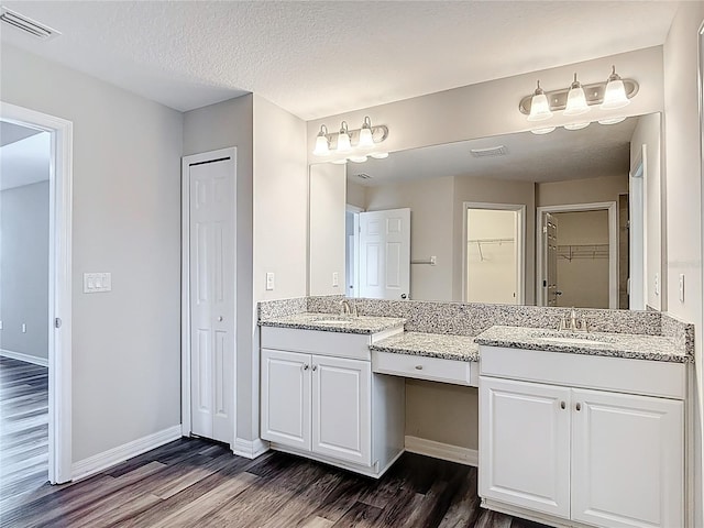 7628 Surf Reed Way, Wesley Chapel, FL 33545 - full bath with wood finished floors, vanity, baseboards, and a textured ceiling