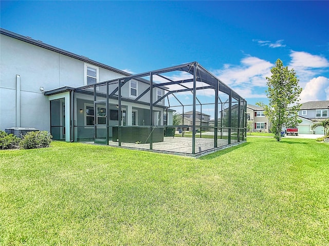 7628 Surf Reed Way, Wesley Chapel, FL 33545 - view of green lawn featuring glass enclosure, a patio area, and central AC unit