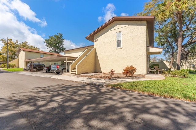 501 E Bay Dr Unit 102, Largo, FL 33770 - view of home's exterior featuring stucco siding and covered parking