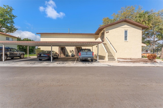 501 E Bay Dr Unit 102, Largo, FL 33770 - covered parking lot featuring stairs
