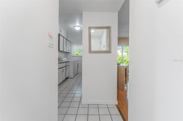 501 E Bay Dr Unit 102, Largo, FL 33770 - hallway featuring light tile patterned floors, washer / dryer, and baseboards