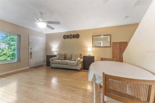 501 E Bay Dr Unit 102, Largo, FL 33770 - living area with a ceiling fan, light wood finished floors, and baseboards