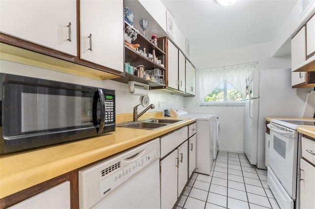 501 E Bay Dr Unit 102, Largo, FL 33770 - kitchen with white appliances, a sink, washer and clothes dryer, white cabinets, and open shelves