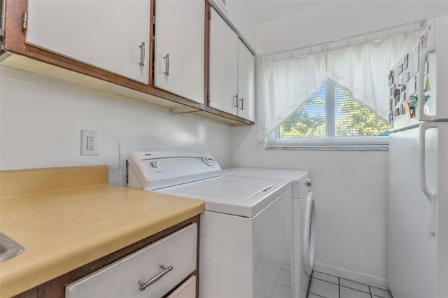 501 E Bay Dr Unit 102, Largo, FL 33770 - washroom with separate washer and dryer, light tile patterned floors, and cabinet space