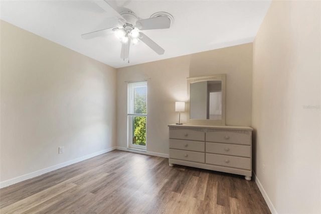 501 E Bay Dr Unit 102, Largo, FL 33770 - bedroom with wood finished floors, baseboards, and ceiling fan