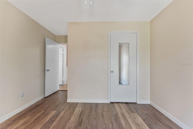 501 E Bay Dr Unit 102, Largo, FL 33770 - unfurnished bedroom with wood finished floors and baseboards