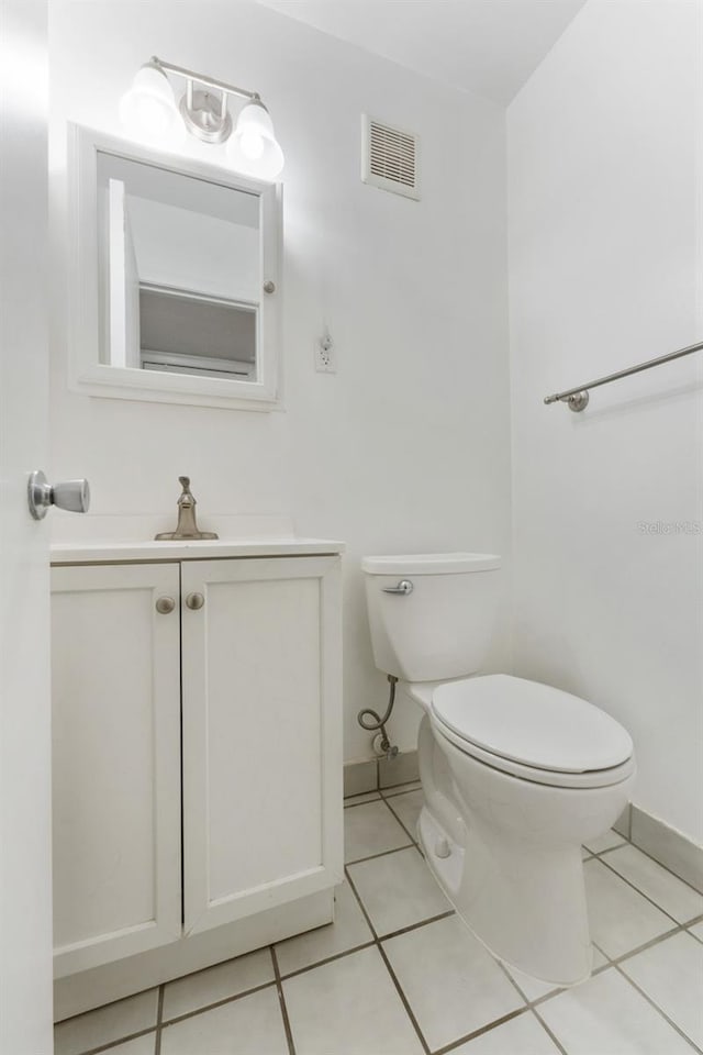 501 E Bay Dr Unit 102, Largo, FL 33770 - half bath featuring toilet, tile patterned floors, baseboards, and vanity
