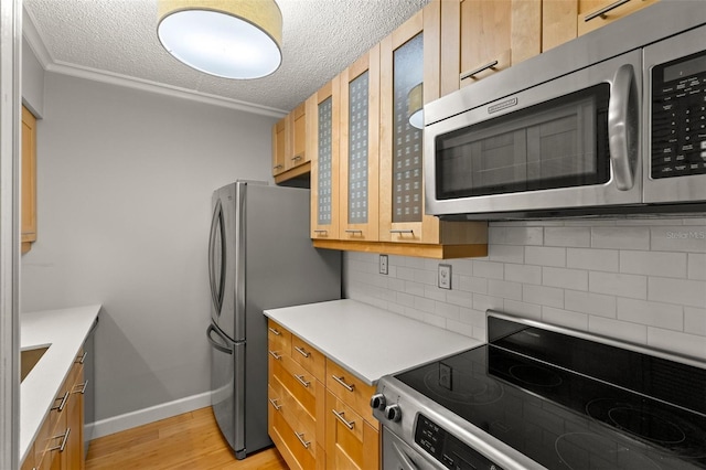 3325 Bayshore Blvd Unit C36, Tampa, FL 33629 - kitchen featuring appliances with stainless steel finishes, tasteful backsplash, a textured ceiling, light wood-style floors, and glass insert cabinets