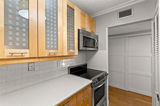 3325 Bayshore Blvd Unit C36, Tampa, FL 33629 - kitchen with appliances with stainless steel finishes, light wood-style flooring, a textured ceiling, decorative backsplash, and light countertops