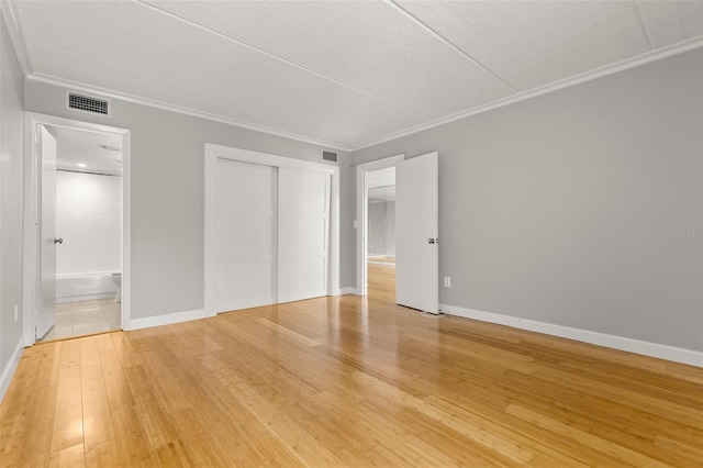 3325 Bayshore Blvd Unit C36, Tampa, FL 33629 - unfurnished bedroom featuring crown molding, light wood-type flooring, a closet, baseboards, and connected bathroom