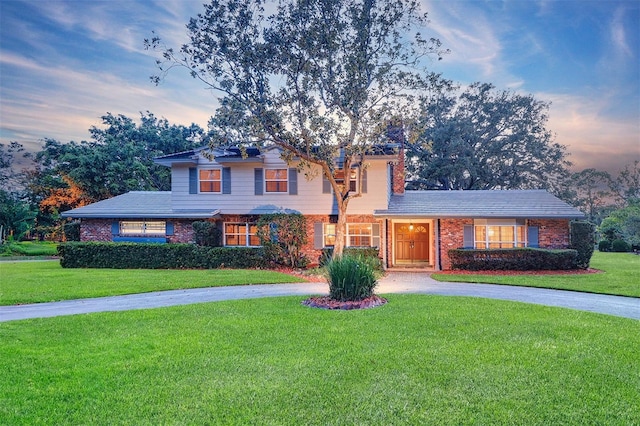 1670 Fox Rd, Clearwater, FL 33764 - traditional home with a front lawn, curved driveway, and brick siding