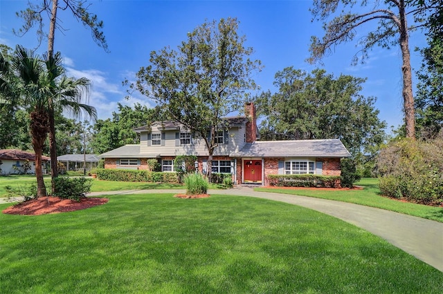 1670 Fox Rd, Clearwater, FL 33764 - view of front of house with a front yard, a chimney, and brick siding