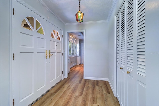 1670 Fox Rd, Clearwater, FL 33764 - entryway featuring light wood-type flooring, baseboards, crown molding, and a textured ceiling