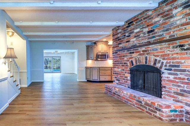 1670 Fox Rd, Clearwater, FL 33764 - unfurnished living room with baseboards, a fireplace, light wood-type flooring, beam ceiling, and a ceiling fan