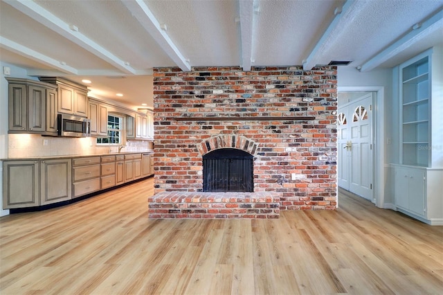1670 Fox Rd, Clearwater, FL 33764 - unfurnished living room with light wood-style flooring, beamed ceiling, a textured ceiling, and a brick fireplace