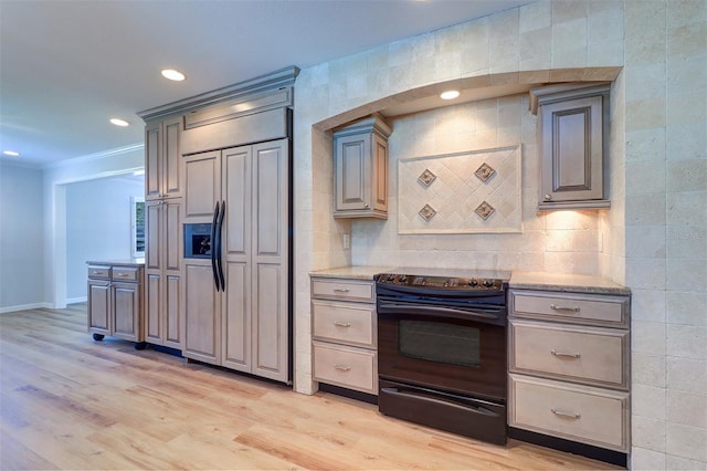 1670 Fox Rd, Clearwater, FL 33764 - kitchen with black range with electric stovetop, paneled refrigerator, light wood-style floors, light stone counters, and recessed lighting