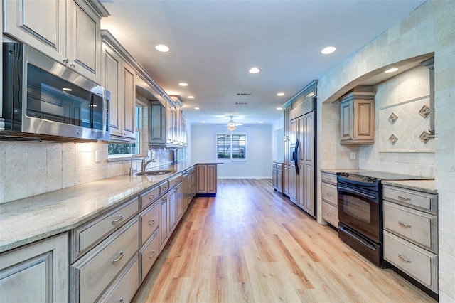 1670 Fox Rd, Clearwater, FL 33764 - kitchen with stainless steel microwave, black / electric stove, a sink, paneled refrigerator, and ceiling fan
