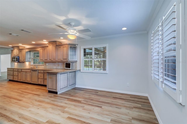 1670 Fox Rd, Clearwater, FL 33764 - kitchen with ornamental molding, baseboards, a peninsula, appliances with stainless steel finishes, and a sink