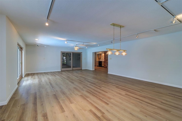 1670 Fox Rd, Clearwater, FL 33764 - empty room featuring rail lighting, light wood-type flooring, and baseboards