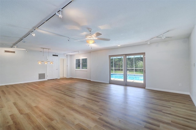 1670 Fox Rd, Clearwater, FL 33764 - spare room featuring rail lighting, baseboards, and light wood-style flooring
