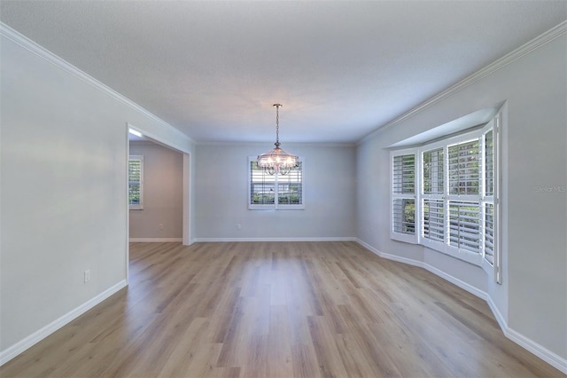 1670 Fox Rd, Clearwater, FL 33764 - empty room featuring light wood-style floors, a chandelier, crown molding, and baseboards