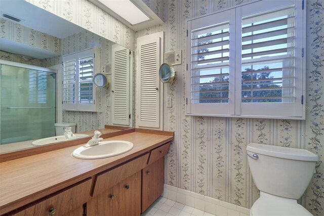 1670 Fox Rd, Clearwater, FL 33764 - full bath featuring wallpapered walls, vanity, toilet, a stall shower, and tile patterned floors