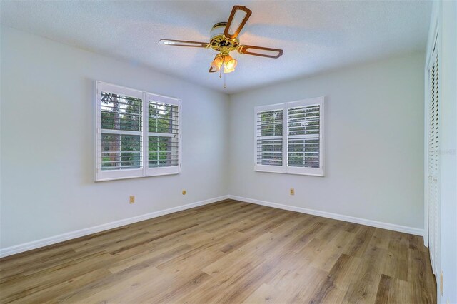 1670 Fox Rd, Clearwater, FL 33764 - unfurnished room with healthy amount of natural light, light wood finished floors, baseboards, and a textured ceiling