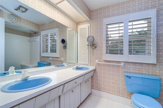 1670 Fox Rd, Clearwater, FL 33764 - full bath featuring double vanity, toilet, tile patterned flooring, and wallpapered walls