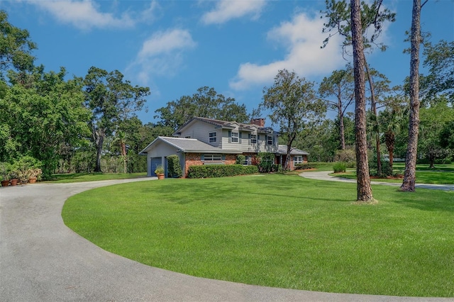 1670 Fox Rd, Clearwater, FL 33764 - view of front of home with a chimney, a front lawn, curved driveway, and brick siding