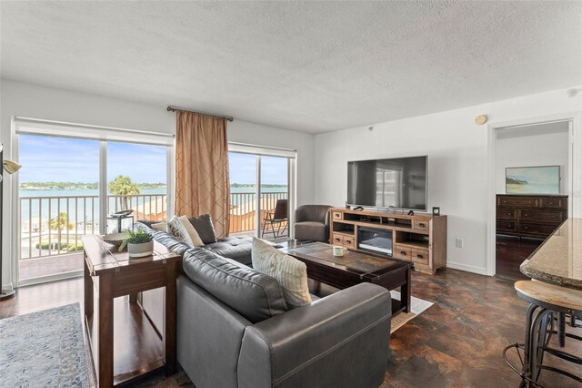 7432 Sunshine Skyway Ln S Unit 402, Saint Petersburg, FL 33711 - living room with a textured ceiling, baseboards, a water view, and concrete flooring