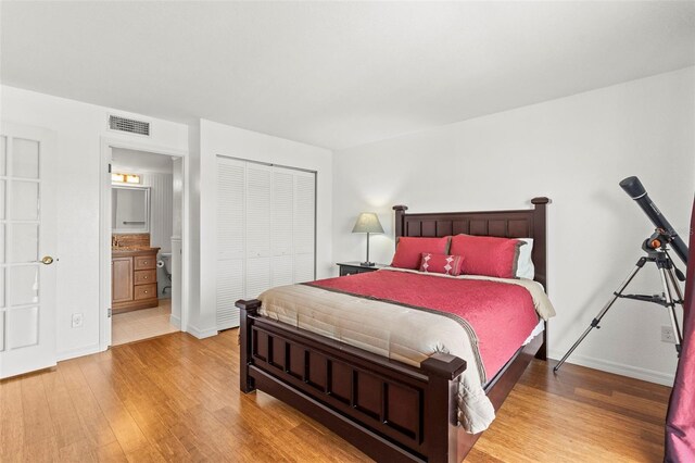 7432 Sunshine Skyway Ln S Unit 402, Saint Petersburg, FL 33711 - bedroom with wood finished floors, baseboards, a closet, and ensuite bath