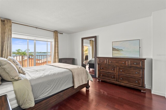 7432 Sunshine Skyway Ln S Unit 402, Saint Petersburg, FL 33711 - bedroom with access to exterior, dark wood finished floors, and baseboards