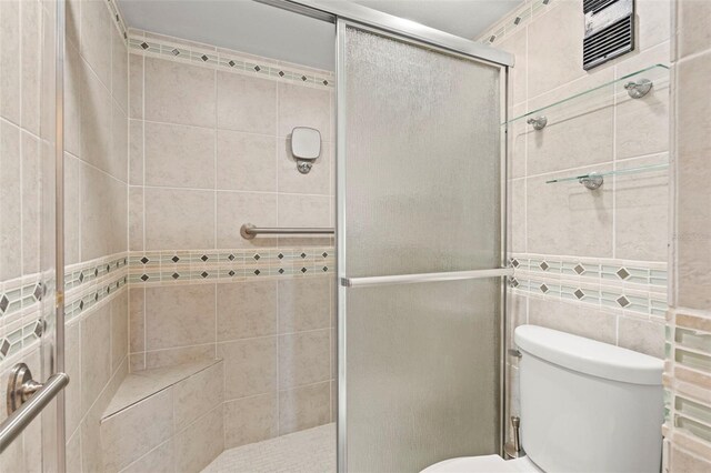 7432 Sunshine Skyway Ln S Unit 402, Saint Petersburg, FL 33711 - full bathroom with toilet, a stall shower, and tile walls
