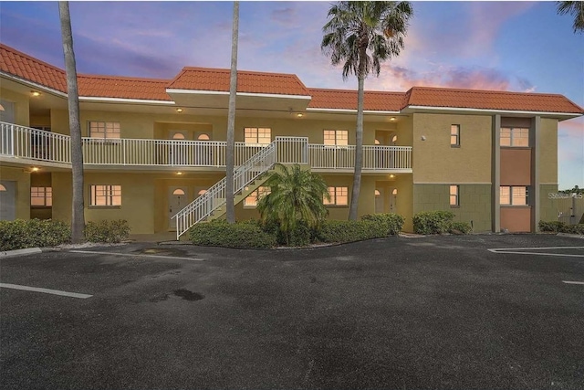 4103 Gulf Blvd Unit 210, St Pete Beach, FL 33706 - view of property with stairs and uncovered parking