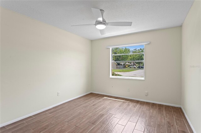 13046 Leverington St, Tampa, FL 33624 - spare room with wood finished floors, a ceiling fan, a textured ceiling, and baseboards