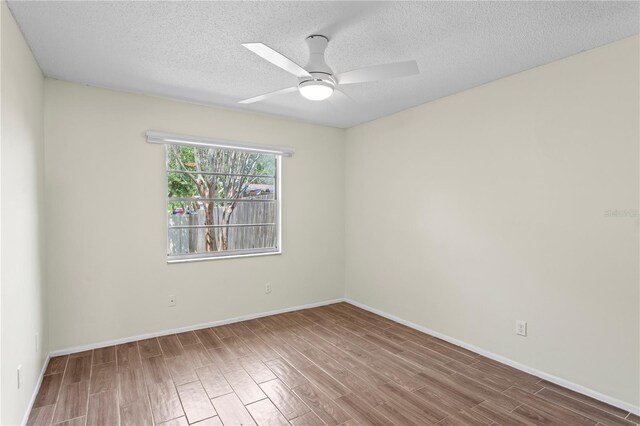 13046 Leverington St, Tampa, FL 33624 - unfurnished room with ceiling fan, wood finished floors, a textured ceiling, and baseboards