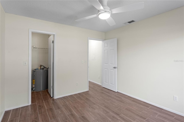 13046 Leverington St, Tampa, FL 33624 - unfurnished bedroom with water heater, wood finished floors, a closet, and baseboards