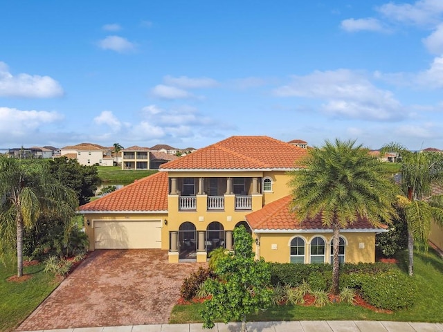 1140 Terralago Way, Kissimmee, FL 34746 - mediterranean / spanish house with a tile roof, a garage, driveway, and stucco siding