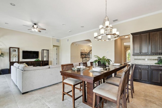 1140 Terralago Way, Kissimmee, FL 34746 - dining area featuring arched walkways, ceiling fan, crown molding, light tile patterned floors, and a chandelier