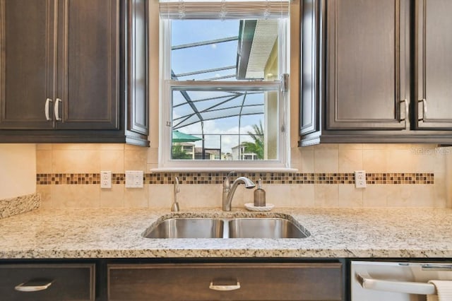 1140 Terralago Way, Kissimmee, FL 34746 - kitchen featuring a sink, dark brown cabinetry, stainless steel dishwasher, light stone counters, and decorative backsplash