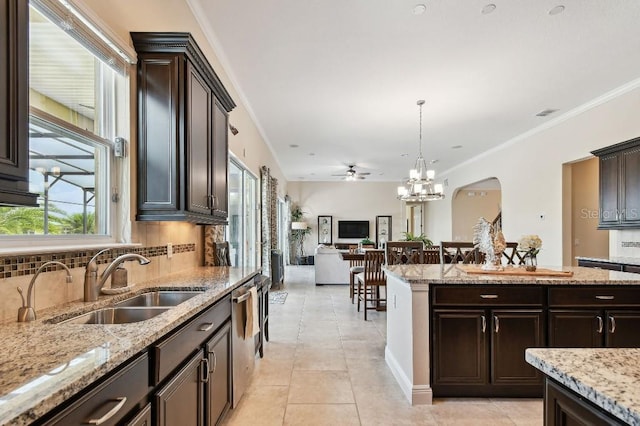 1140 Terralago Way, Kissimmee, FL 34746 - kitchen with a sink, dishwasher, decorative backsplash, dark brown cabinetry, and pendant lighting