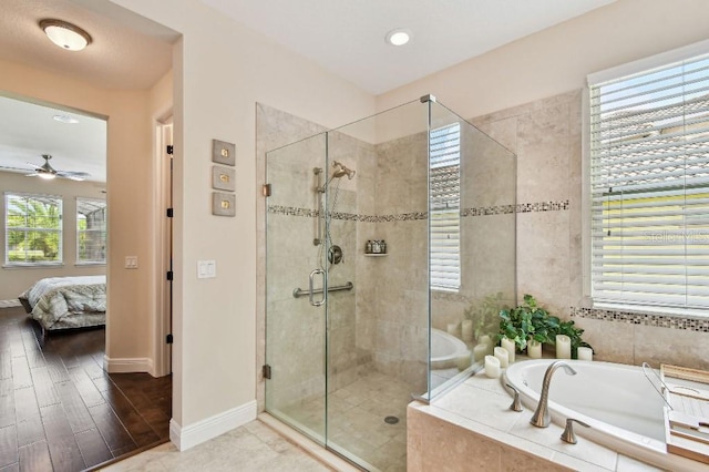 1140 Terralago Way, Kissimmee, FL 34746 - ensuite bathroom with a bath, a shower stall, a ceiling fan, baseboards, and wood finished floors
